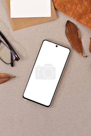 Photo for Blank smartphone screen mock up, stationery, dried leaves on a neutral beige background. Minimalist autumn, fall business brand template, social media blog design - Royalty Free Image