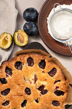 Photo for Autumn plum pie, plums, flour on plate, flat lay. Fall seasonal fruit Thanksgiving day bakery. - Royalty Free Image