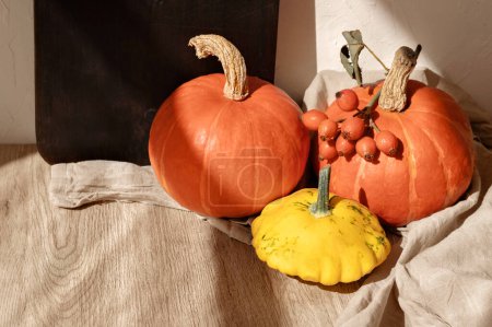 Foto de Concepto de cosecha de verduras de otoño, calabazas de naranja, calabaza, bayas en el fondo de la mesa de la cocina con espacio para copiar. - Imagen libre de derechos