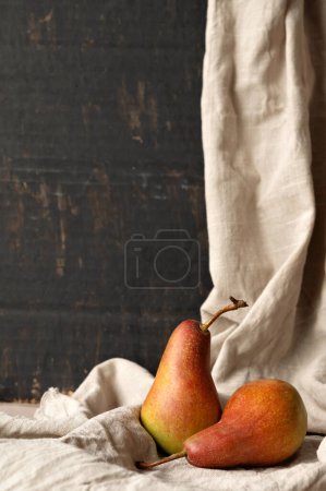 Photo for Red pears on linen tablecloth, on black abstract background. Fall fine art still life. - Royalty Free Image