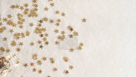 Foto de Fondo festivo minimalista estético navideño, confeti estrella dorada sobre textura neutra de lino beige. Año Nuevo, plantilla de diseño de fiesta de celebración de Navidad. - Imagen libre de derechos
