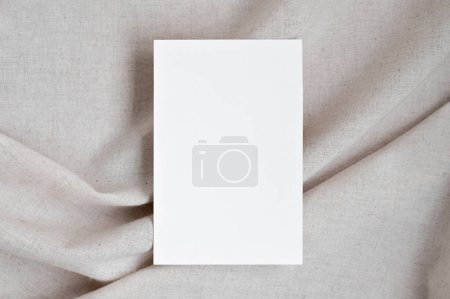 Photo for Blank white paper card mockup on neutral beige oat color crumpled linen fabric background with soft shadows, elegant boho wedding invitation or business branding template. - Royalty Free Image
