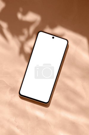 Photo for Mobile phone with empty white screen on peach marble table background with aesthetic natural sunlight shadows, Trendy color 2024. - Royalty Free Image