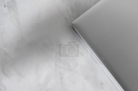 Photo for Neutral lifestyle business branding background template with copy space, gray closed laptop on marble table with soft abstract sun light shadows. - Royalty Free Image