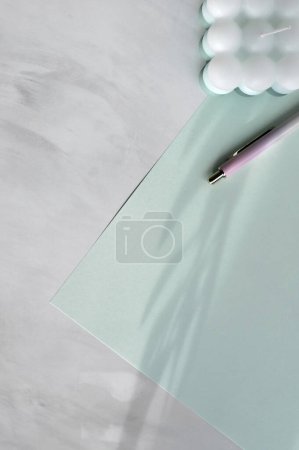 Foto de Redacción plana minimalista neutral del negocio del pastel verde y blanco, hoja de papel y pluma sobre fondo de mesa de mármol, espacio de copia. - Imagen libre de derechos