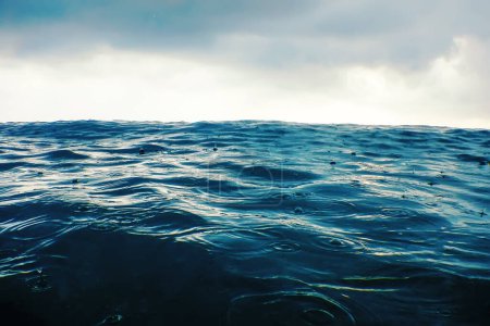 Foto de Ola de mar en la lluvia de cerca, vista de bajo ángulo fondo de agua - Imagen libre de derechos