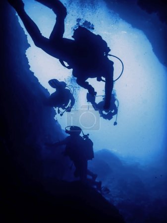 Scuba Divers Silhouette in Underwater Cave