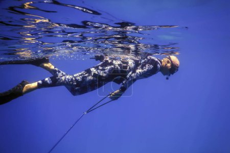 Téléchargez les photos : Pêcheur de lances nage à la surface de la mer, Pêche de lances - en image libre de droit