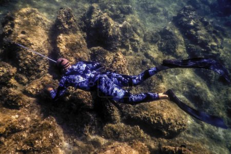 Spearfisher Swims on the Rocky Seabed, Spearfishin