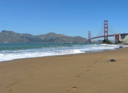 Photo for An empty Baker Beach with footprints in San Francisco, showing the Pacific Ocean, Golden Gate Bridge, and Marin Headlands from a low angle. - Royalty Free Image