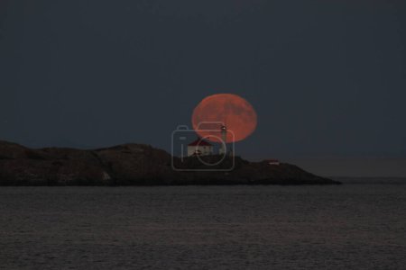 Photo for The full moon rising behind the lighthouse at Trial Islands, off Victoria, BC, Canada. - Royalty Free Image