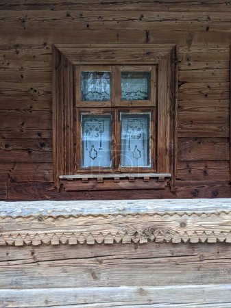 Photo for The open-air museum of traditional wooden architecture in the national park in Ukraine, wooden house window view - Royalty Free Image