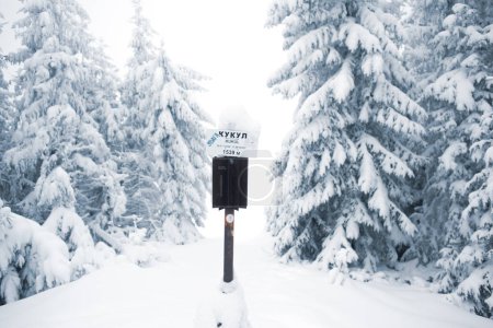 Foto de Poste de señal de montaña kukul en la colina de invierno cubierta de nieve - Imagen libre de derechos