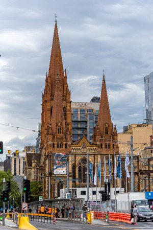 Foto de Melbourne, Victoria / Australia - 11 / 03 / 2019 La Catedral de San Pablo es el único edificio neogótico entre un mar de estructuras modernas en Federation Square. - Imagen libre de derechos