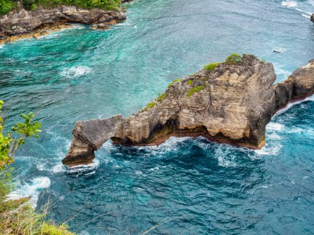 Photo for Atuh Beach is a Rustic, isolated cove beneath a sheer cliff face, with a sandy beach offshore rock formations. - Royalty Free Image