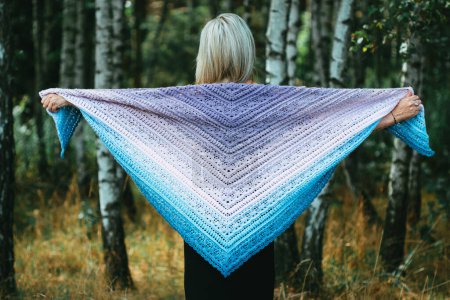 Photo for Fourty years old woman show hand crochet made by herself ombre shawl in birch grove - Royalty Free Image