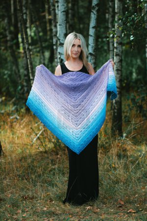 Photo for Fourty years old woman show hand crochet made by herself ombre shawl in birch grove - Royalty Free Image