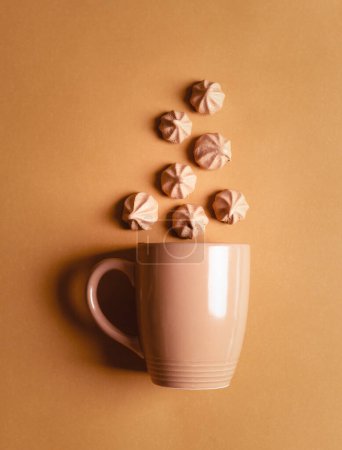Téléchargez les photos : Tasse à café avec biscuits meringués au chocolat sur fond beige. - en image libre de droit