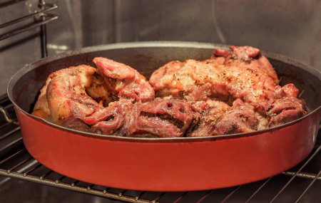 Téléchargez les photos : Épaule de porc cuite au four dans une casserole ronde en métal - en image libre de droit