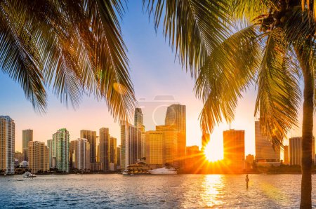 Miami, Florida Skyline mit Sonnenstrahlen, die durch die Wolkenkratzer scheinen. Miami ist eine Stadt mit einer Mehrheit von Minderheiten und ein wichtiges Zentrum und führend in den Bereichen Finanzen, Handel, Kultur, Kunst und internationaler Handel..