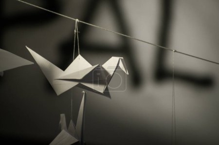 Foto de Japanese folded Origami cranes hanging on with strings. Hundreds handmade paper birds isolated with copy space. 1000 thousand crane tsuru sculpture topic. Symbol of peace, faith, health, wishes, hope - Imagen libre de derechos