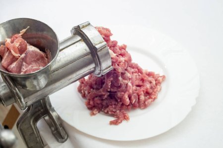 Téléchargez les photos : Viande de porc broyée, viande hachée et un broyeur de métal, mise au point douce gros plan - en image libre de droit