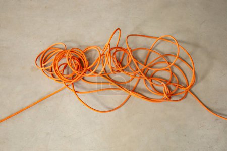 Foto de Tangled orange electrical cord, impossible problem concept - Imagen libre de derechos