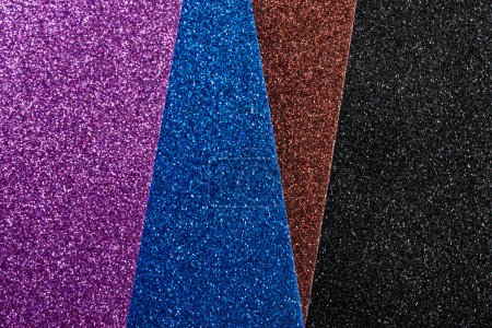 violet, blue brown and black glitter sheets arranged in an angle, soft focus texture