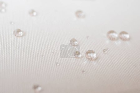 Photo for Clear water drops on white canvas, soft focus close up - Royalty Free Image