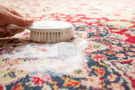 Photo for Male hand holding a white brush, on a natural fiber rug with white foam, abstract texture - Royalty Free Image