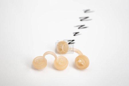 Foto de Tapones nasales de silicona, dispositivo anti ronquidos aislado en blanco - Imagen libre de derechos