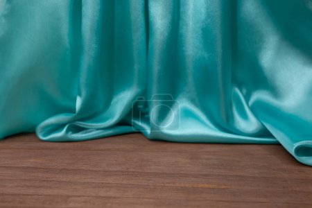 plancher en bois vide avec élégant ondulé rideaux en tissu de satin turquoise, déconcentré en arrière-plan, fond de placement de produit