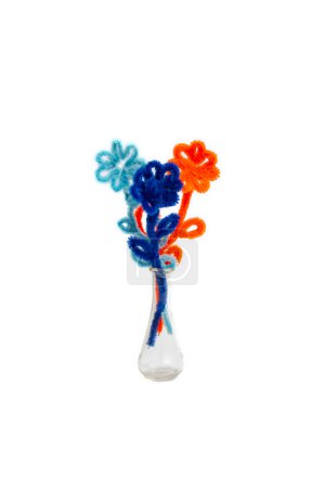 Pipe cleaner fluffy wires flowers in a glass vase isolated on white background