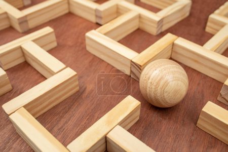 Wooden maze made with wood blocks and a wood sphere, finding labyrinth way out concept