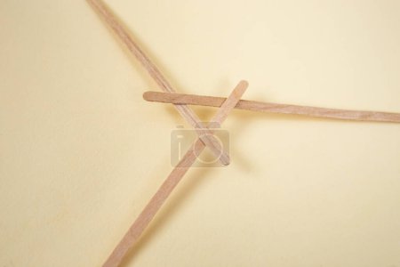 Palos de madera de bambú demostrando una estructura de marco recíproco, en beige  