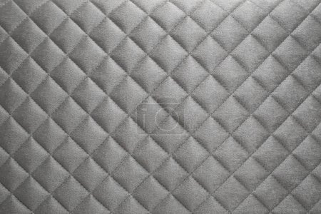 motif en forme de diamant sur un canapé gris velours, mise au point douce de près, abstrait  