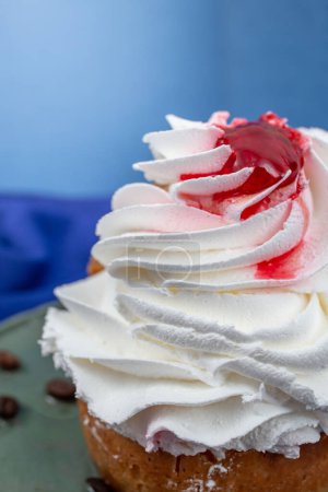 Whipped cream texture on a french savarin cake with red fruit syrup , soft focus crop