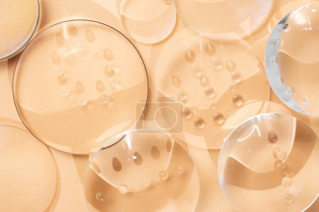 Clear magnifying lenses on bright cream background, with  water drops and shadows 