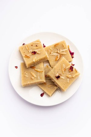 Photo for Rava barfi or sooji burfi or barfee is an Indian Sweet made with semolina, sugar, ghee and almonds - Royalty Free Image