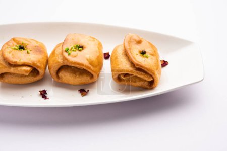 Téléchargez les photos : Lavang Latika : doux indien traditionnel. Forme croissant, frite, trempée dans du sirop de sucre. Servi pendant les festivals. - en image libre de droit