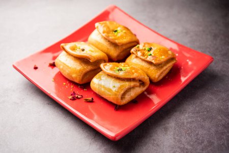 Téléchargez les photos : Lavang Latika : doux indien traditionnel. Forme croissant, frite, trempée dans du sirop de sucre. Servi pendant les festivals. - en image libre de droit