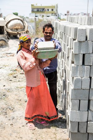 Téléchargez les photos : Asiatique indien femme travail ou coolie travail à la construction site portant briques sur son tête. - en image libre de droit
