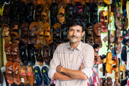 Photo for Indian man selling footwear or chappal at roadside shop - Royalty Free Image