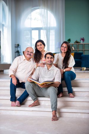 Foto de Familia india mirando Álbum de fotos mientras está sentado en el sofá, momento feliz - Imagen libre de derechos