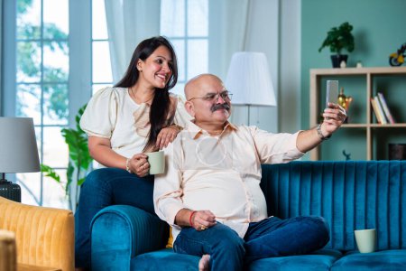 Photo for Indian old age father with young daughter using smartphone for video call or self portrait - Royalty Free Image