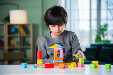 Photo for Indian asian boy playing with colourful toy blocks at home - Royalty Free Image