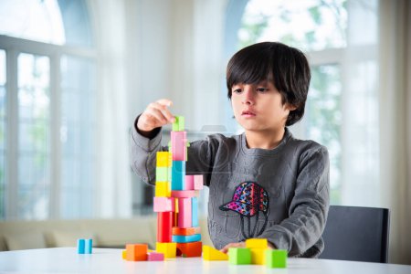 Photo for Indian asian boy playing with colourful toy blocks at home - Royalty Free Image