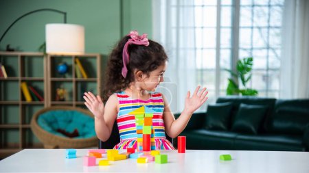 Photo for Indian little girl playing with wooden blocks toys on the table at home - Royalty Free Image