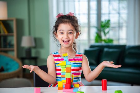 Foto de India niña jugando con bloques de madera juguetes en la mesa en casa - Imagen libre de derechos