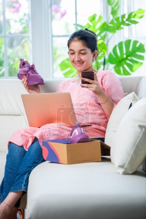 Photo for Indian young girl online shopping or returning shoes - Royalty Free Image